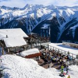 Des skieurs profitent de la terrasse sur le domaine skiable de la station de Bellwald dans le Haut-Valais